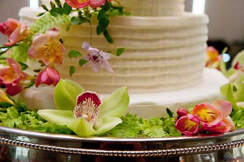The Base Of The Delicious Wedding Cake Was Surrounded By Additional Flowers
